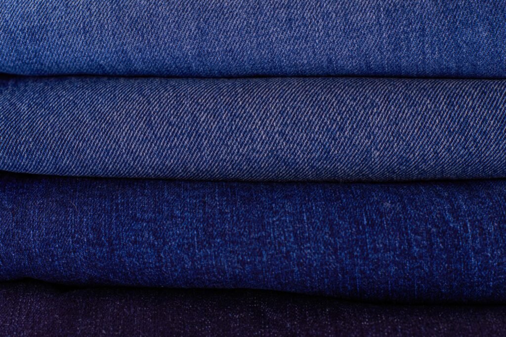Pila de jeans doblados mostrando distintos grados de desteñido