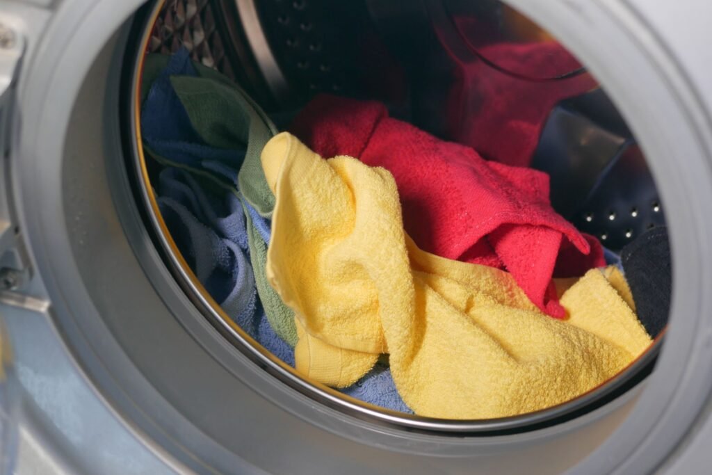 Ropa de colores dentro de una lavadora, lista para teñir