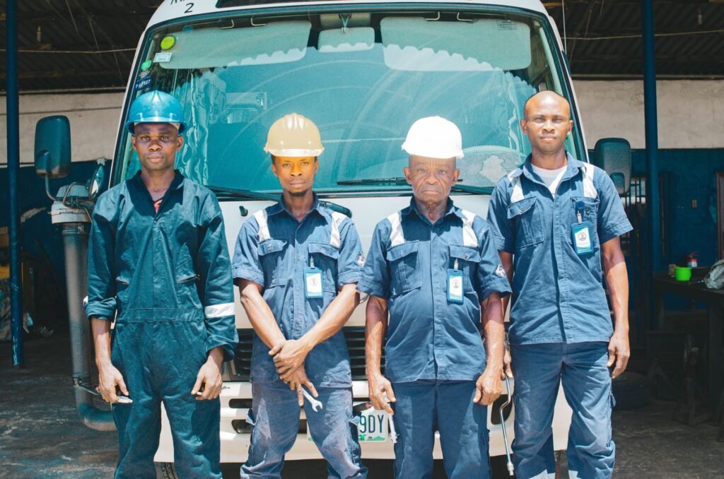 Grupo de trabajadores con uniformes de taller y cascos de seguridad