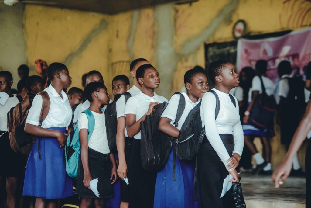 Grupo de escolares con uniforme y mochila formados en el colegio