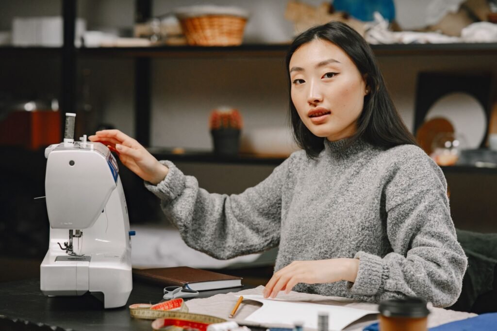 Persona trabajando en una máquina de coser dentro de un taller pequeño
